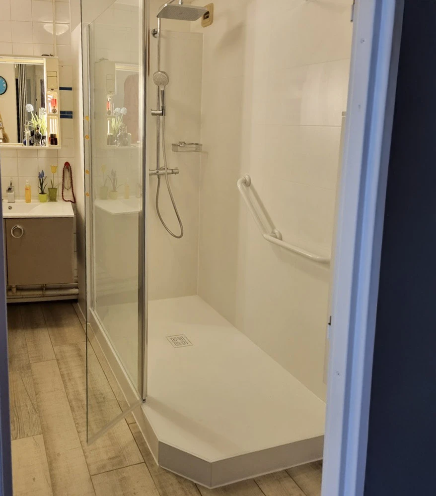 Salle de bains moderne avec douche à l'italienne accessible, receveur extra-plat blanc, paroi vitrée transparente, barre d'appui murale, mitigeur thermostatique avec douchette