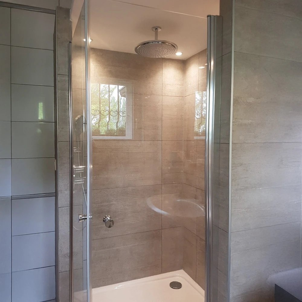 Salle de bains moderne avec douche à l'italienne ouverte, carrelage beige grand format au sol et murs