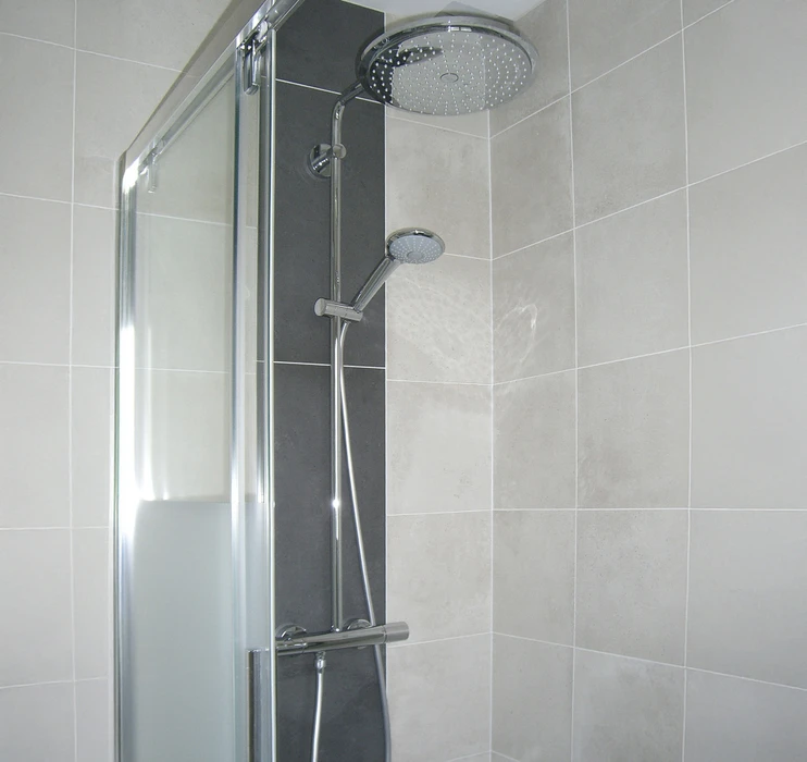 Salle de bain moderne avec douche à l'italienne, carrelage brun et beige, parois vitrées, receveur extra-plat blanc