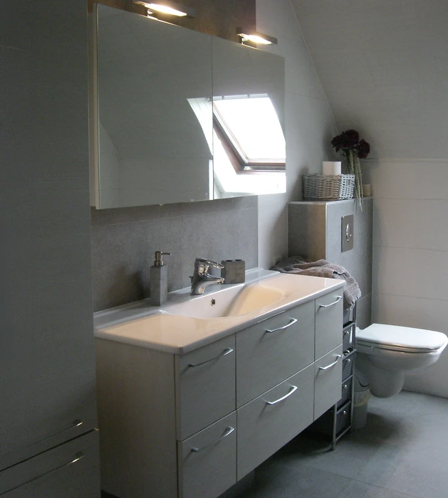Salle de bain mansardée moderne avec douche à l'italienne et toilettes suspendues