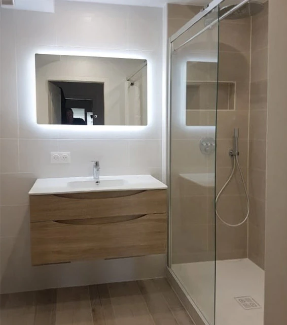 Salle de bain moderne avec douche à l'italienne équipée d'une porte vitrée transparente et profilés chromés