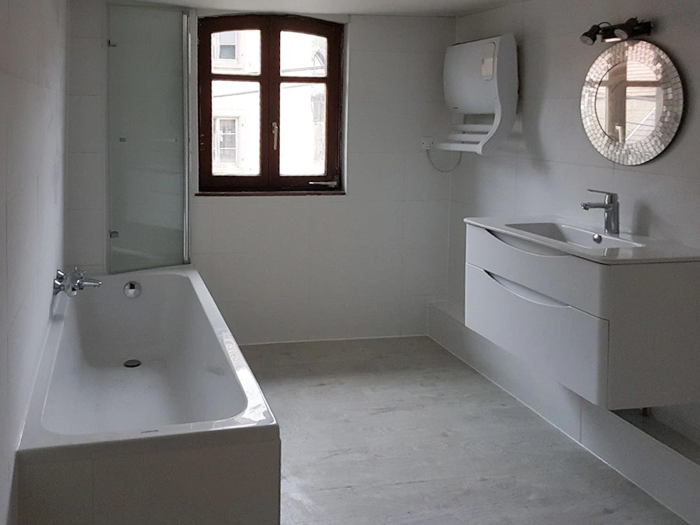 Salle de bain moderne avec douche à l'italienne équipée d'une cabine de douche en verre trempé avec profilés chromés et porte coulissante