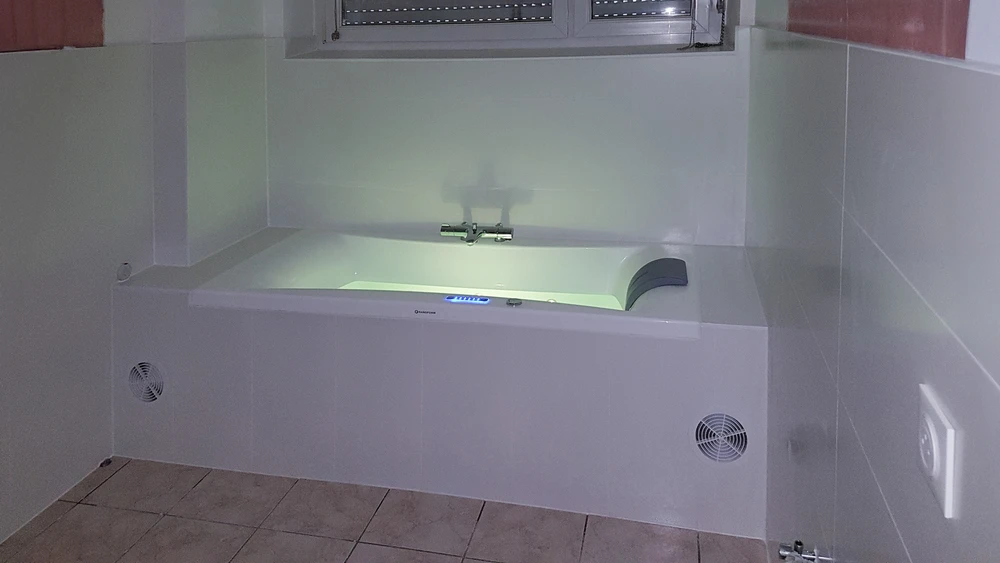 Salle de bains moderne rénovée avec baignoire encastrée et meuble vasque suspendu blanc