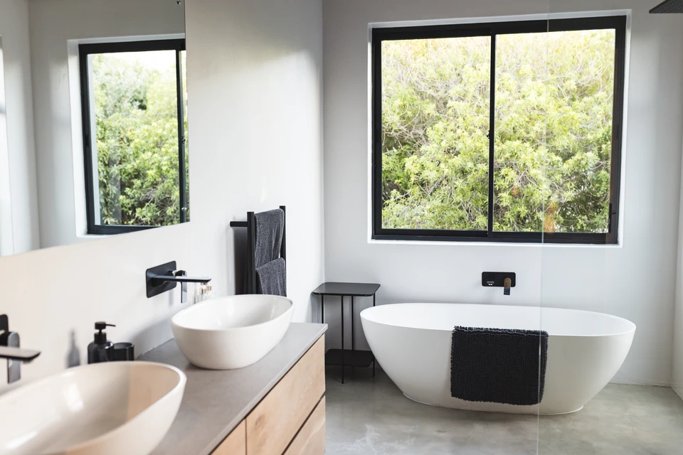 Salle de bain moderne avec lavabo et miroir, serviette blanche suspendue à un porte-serviettes annulaire chromé