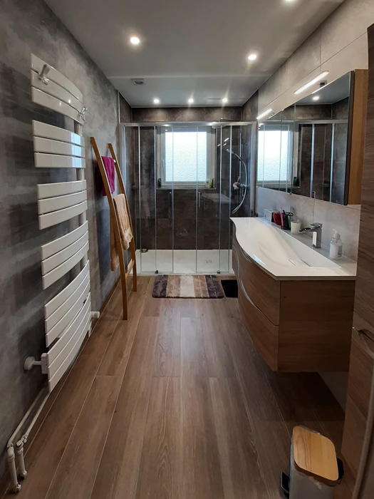 Salle de bain moderne avec douche d'angle à portes coulissantes en verre trempé transparent