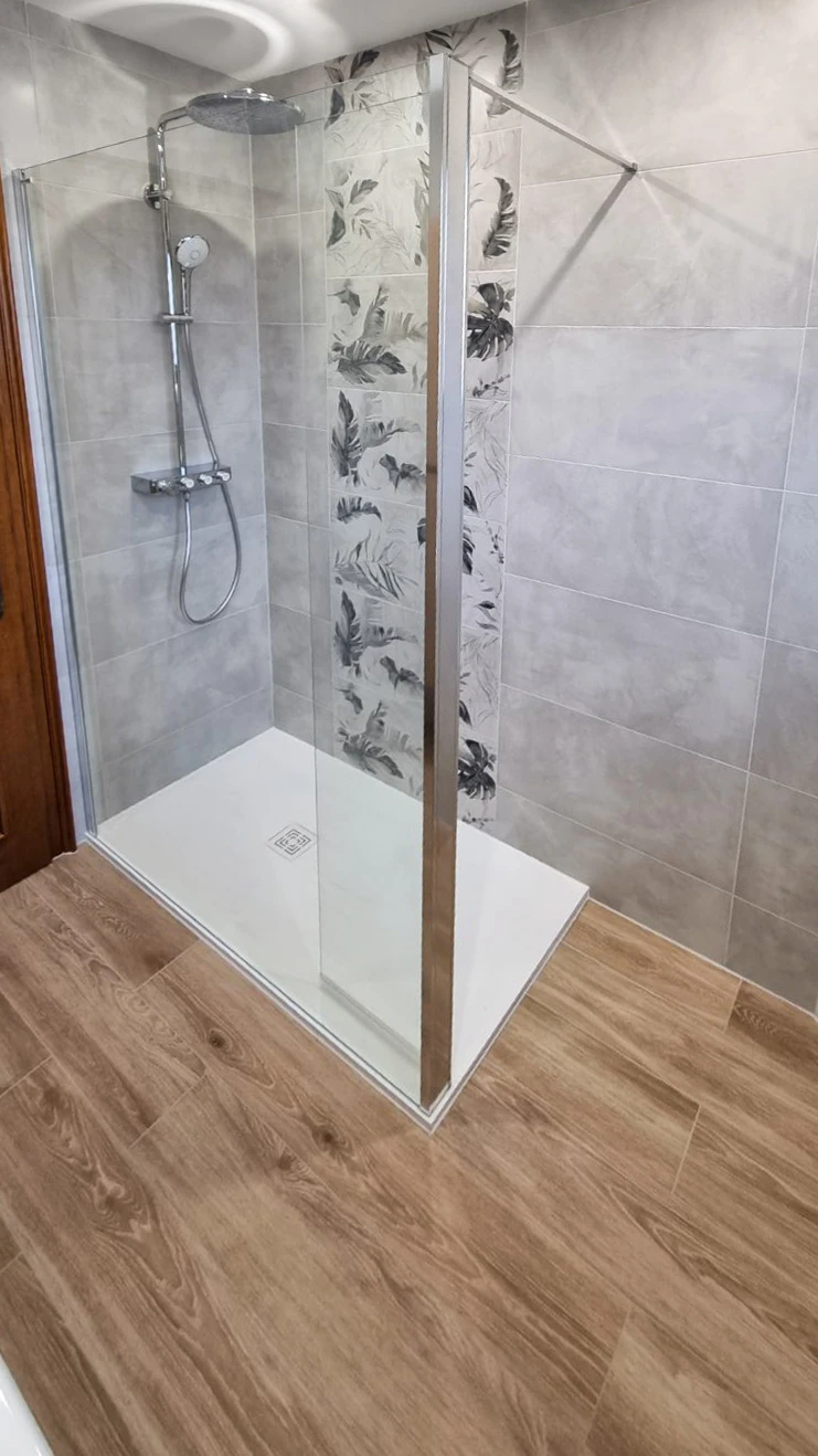 Salle de bain moderne avec douche d'angle à portes coulissantes en verre trempé transparent