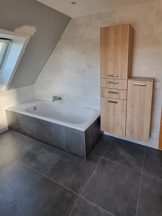 Salle de bain moderne avec douche à l'italienne vitrée, meuble vasque suspendu en bois naturel avec plan blanc intégré, colonne de rangement assortie et miroir éclairé