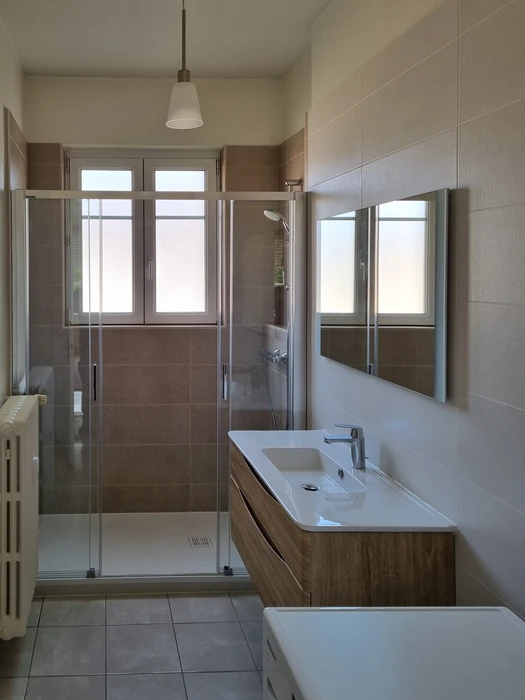 Salle de bain moderne avec douche à l'italienne, carrelage brun et beige, parois vitrées, receveur extra-plat blanc